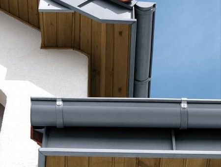 Maison avec plusieurs surfaces de toits et des gouttières demi-rondes en zinc RHEINZINK Maison avec plusieurs surfaces de toits et des gouttières demi-rondes en zinc RHEINZINK